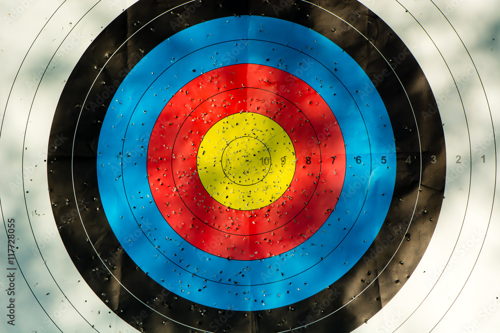 Archery target with arrow holes. Gold, red, blue and black competition
