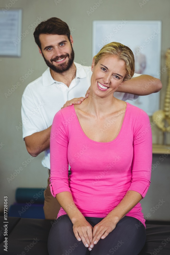 Fototapeta premium Male physiotherapist giving neck massage to female patient