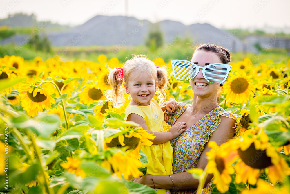 Mom and daughter in the field of sunflowers Mom and daughter in the field of sunflowers