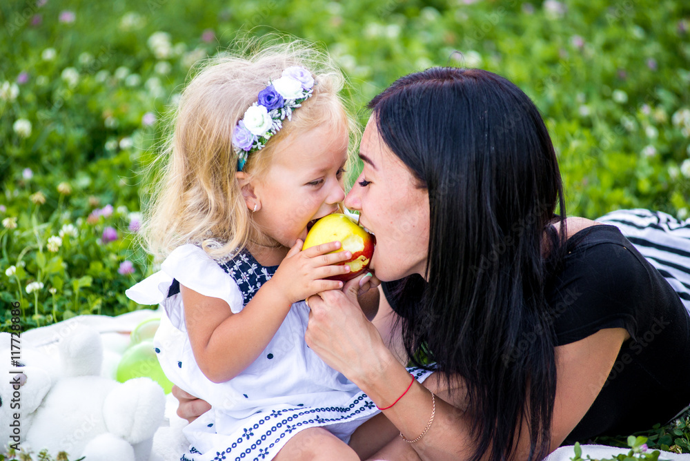 Mother and her child enjoy the early spring, eating apple, happy. Mother and her child enjoy the early spring, eating apple, happy.