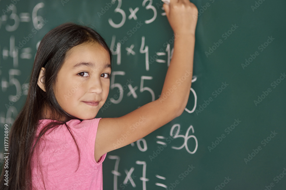Girl making some exercises on the blackboard