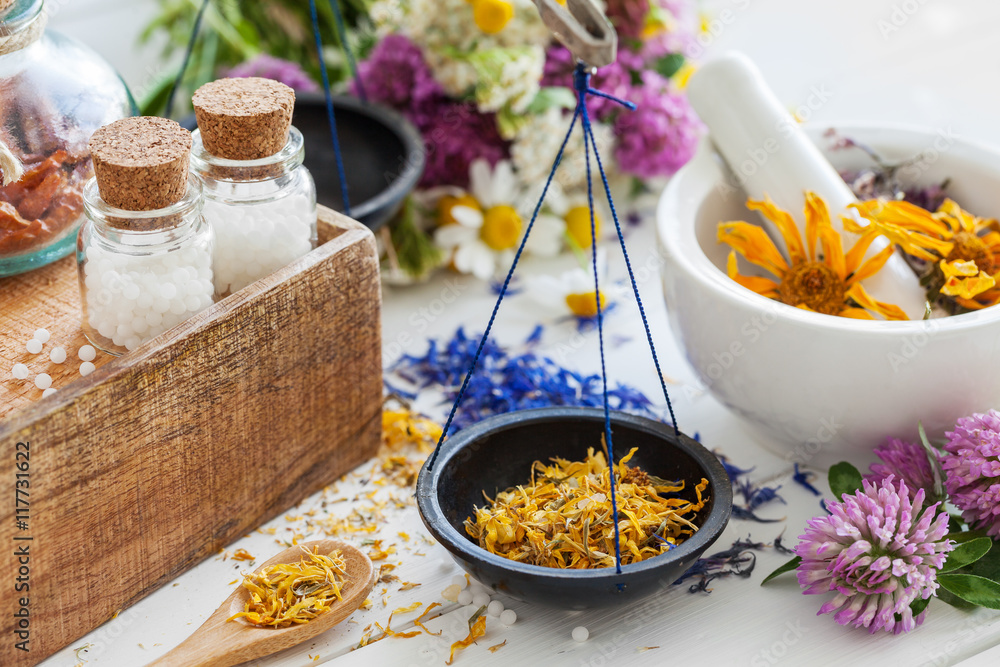 Bottles of homeopathy globules, scales and mortar of herbs Bottles of homeopathy globules, scales and mortar of herbs