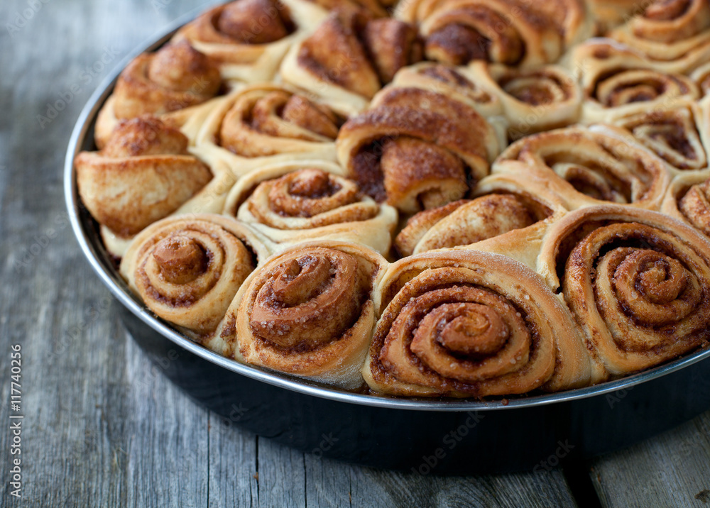 cinnamon buns on wooden surface cinnamon buns on wooden surface