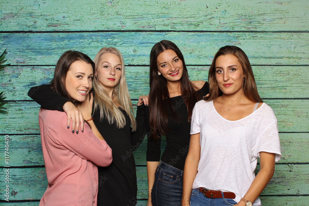 4 Freundinnen stehen vor einer Fotobox 4 Mädchen lächeln in eine