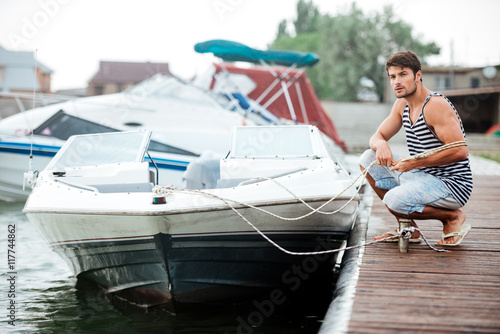 Young handsome man preparing boat to start a journey