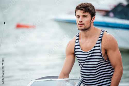 Handsome bearded sailor man driving his motor boat