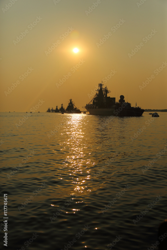 silhouette of military ships on sunset