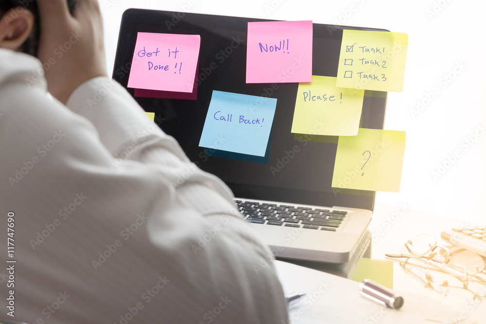 Businessman working on his desk with sticky notes with messages stuck to a  laptop computer screen. Pending work concept. Stock Photo | Adobe Stock