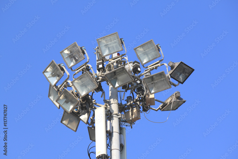 Many bright spotlights on a pole against the blue sky Many bright spotlights on a pole against the blue sky