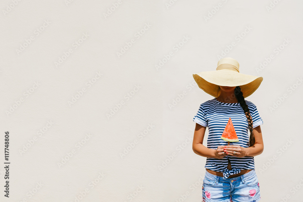 Happy young woman holding watermelon on cream background Happy young woman holding watermelon on cream background
