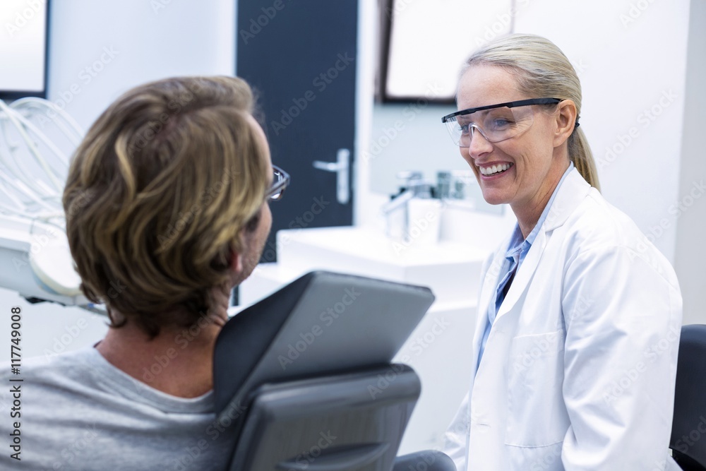 Obraz premium Female dentist interacting with male patient