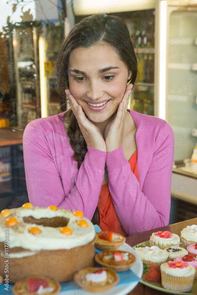 Happy woman looking at dessert display
