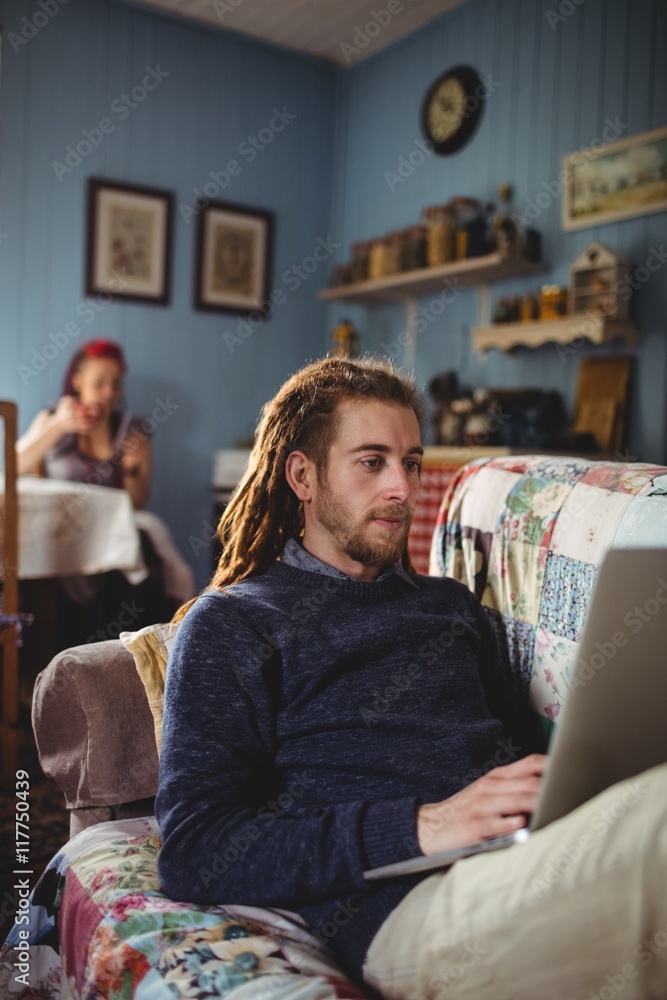 Man using laptop while sitting on sofa at home Man using laptop while sitting on sofa at home