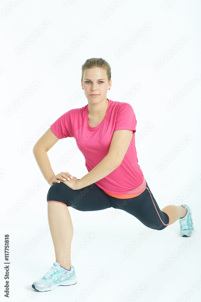 Portrait of a young caucasian woman stretching legs warm up in studio isolated on white background. Portrait of a young caucasian woman stretching legs warm up in studio isolated on white background.