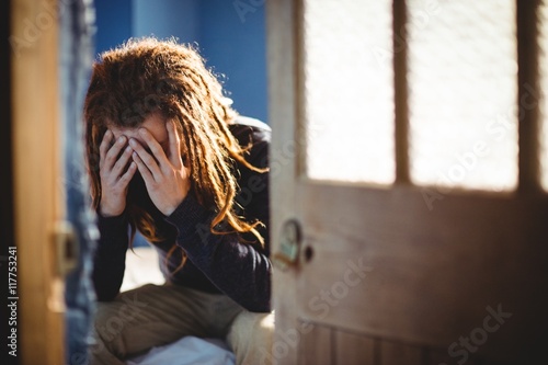 Sad hipster man sitting on bed