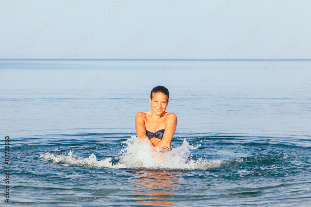Young cute woman having fun in the sea