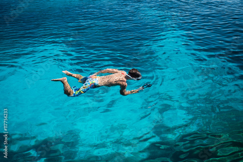 Junger Mann schwimmt und filmt mit Unterwasserkamera
