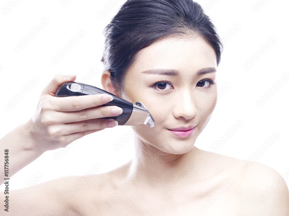 young asian woman using a face spa device young asian woman using a face spa device