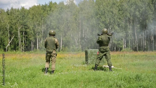 Soldier in camouflage uniforms fires anti-tank grenade launcher photo