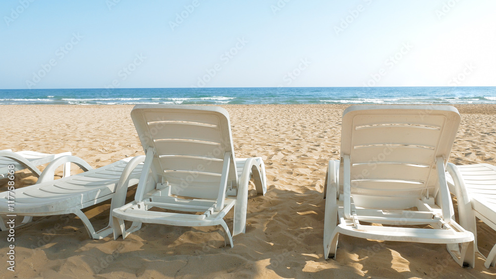 White chairs are placed on the beach for people to relax or sunbath. Beaches make a wonderful vacation spot. One of the most beautiful sceneries.