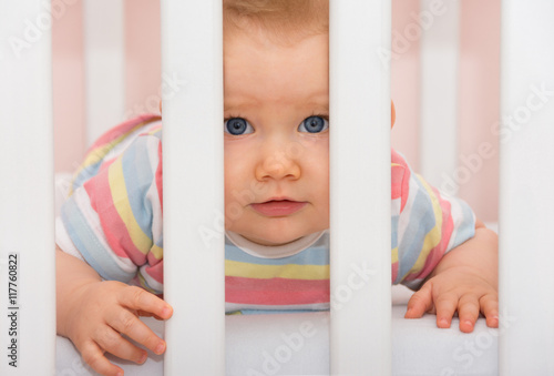 Huhu... Baby schaut aus Gitterbett photo