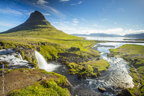 waterfall under triangle rock in summer day in Iceland