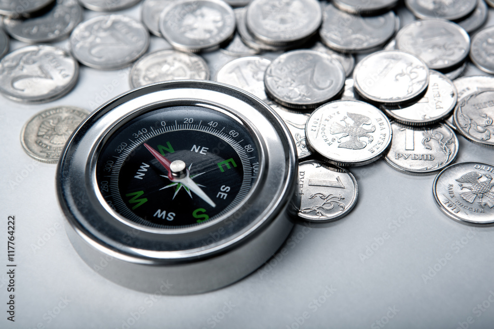 pile of coins with compass