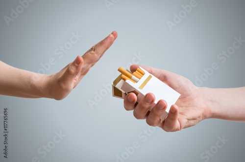 Quitting smoking concept. Hand is refusing cigarette offer. photo