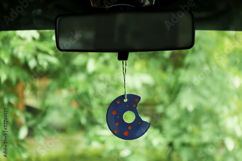 Air freshener hanging in the car on green natural background photo