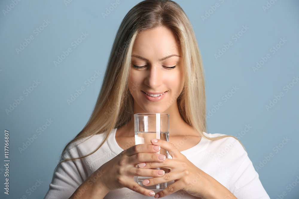 Beautiful girl drinking water on blue background Beautiful girl drinking water on blue background