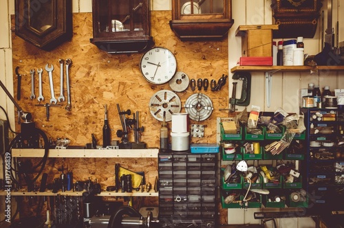Horologists workshop with clock repairing tools, equipment and clocks on the wall