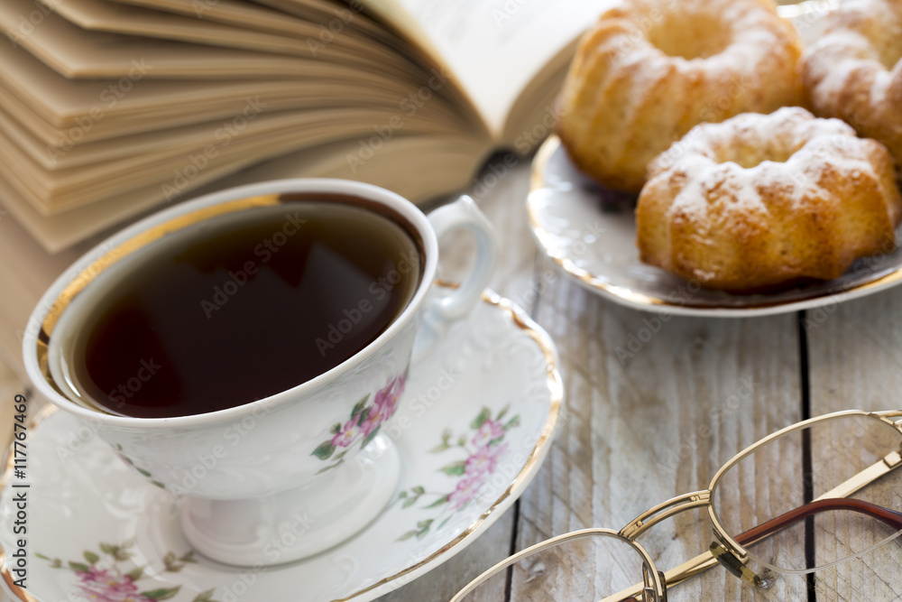 Coffee with cupcakes and book on the wooden table Coffee with cupcakes and book on the wooden table