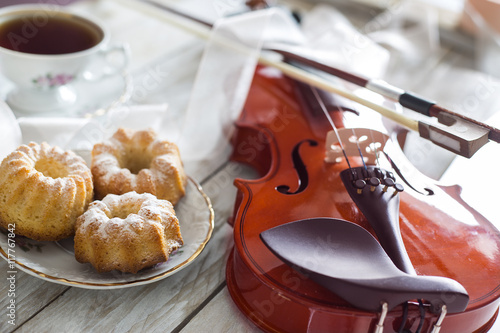 Coffee with cupcakes and violin on the wooden table