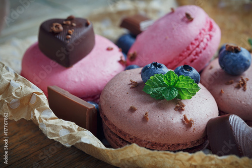 Macaroon with fresh blueberries and chocolate on rustic wooden b