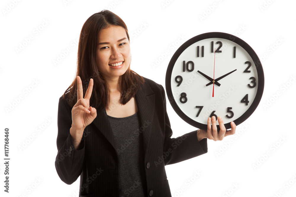 Young Asian business woman show victory sign with a clock.