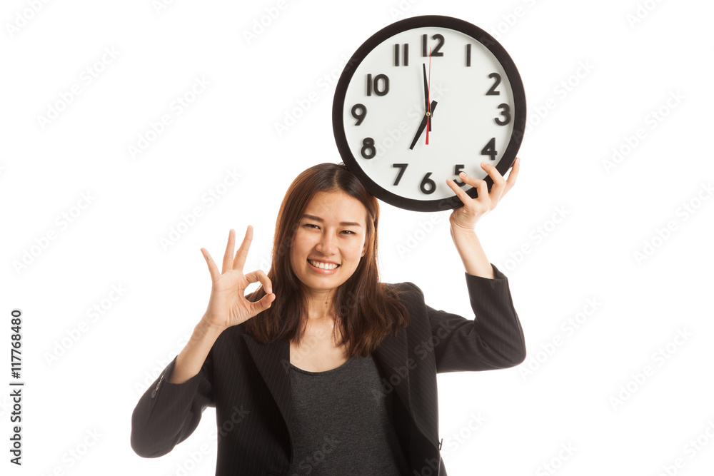 Young Asian business woman show OK with a clock. Young Asian business woman show OK with a clock.