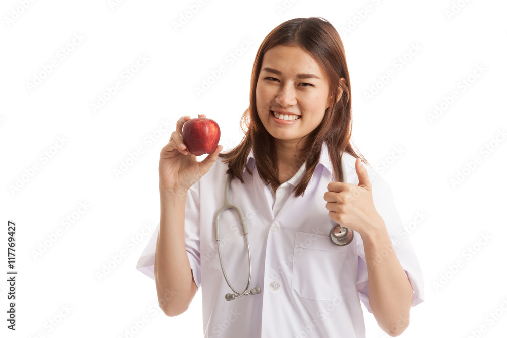 Young Asian female doctor thumbs up with apple. Young Asian female doctor thumbs up with apple.