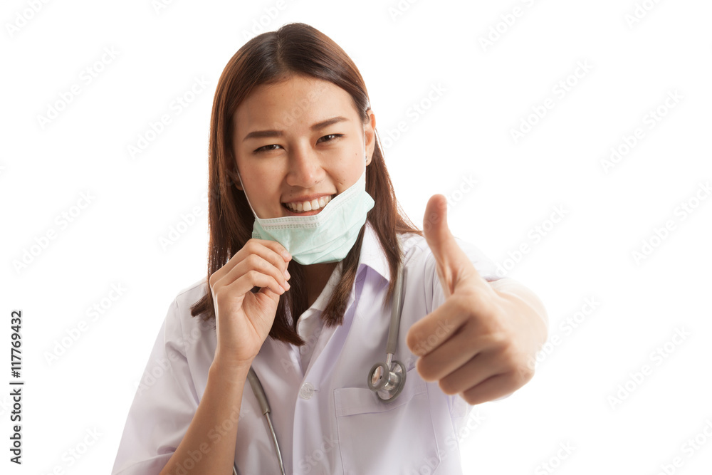 Young Asian female doctor pull mask and show thumbs up. Young Asian female doctor pull mask and show thumbs up.