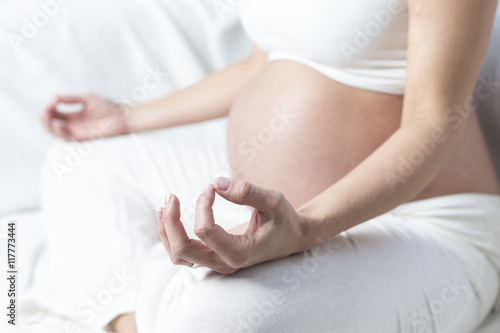 Schwangere Frau sitzend praktiziert Yoga