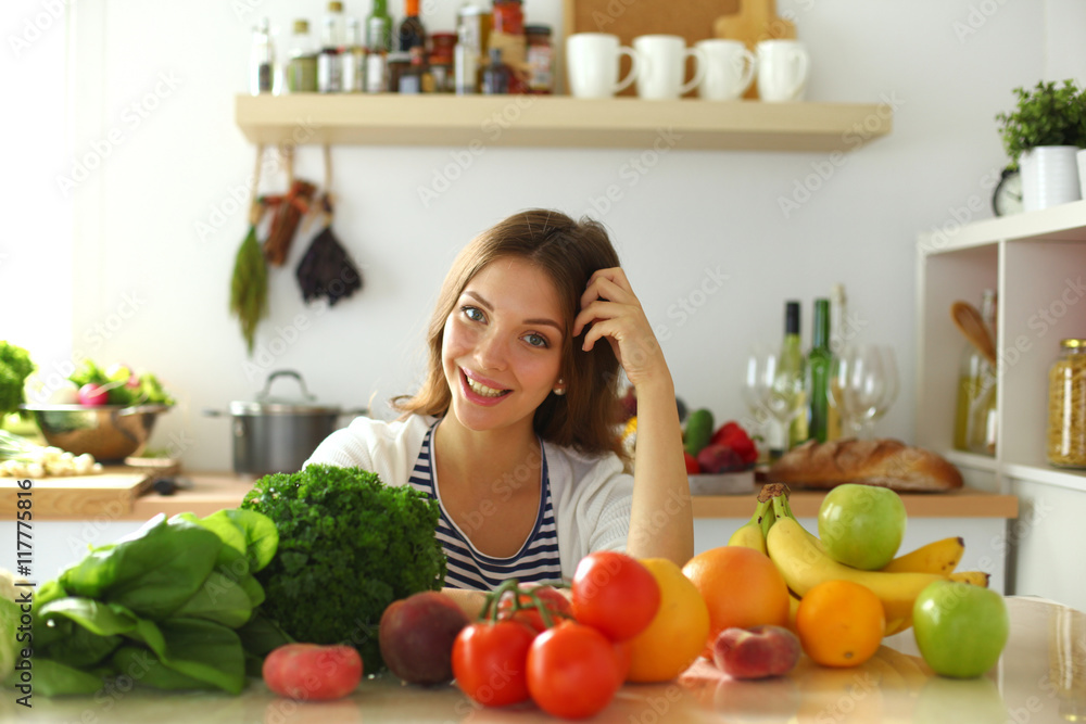 Young woman sitting near desk in the kitchen Young woman sitting near desk in the kitchen