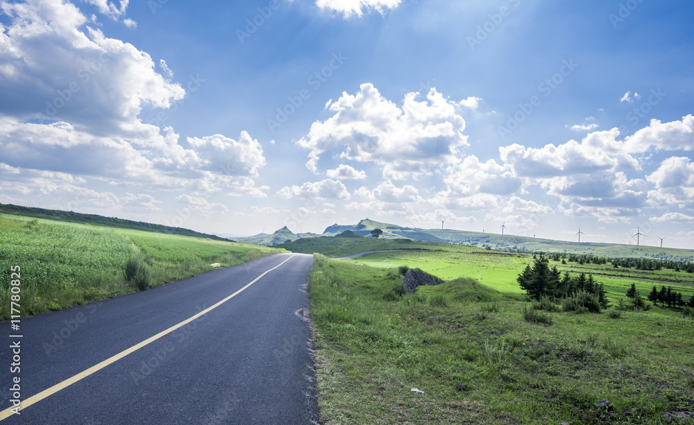 empty asphalt road on grassland empty asphalt road on grassland