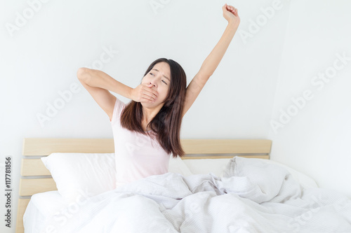 Woman feeling tired on bed