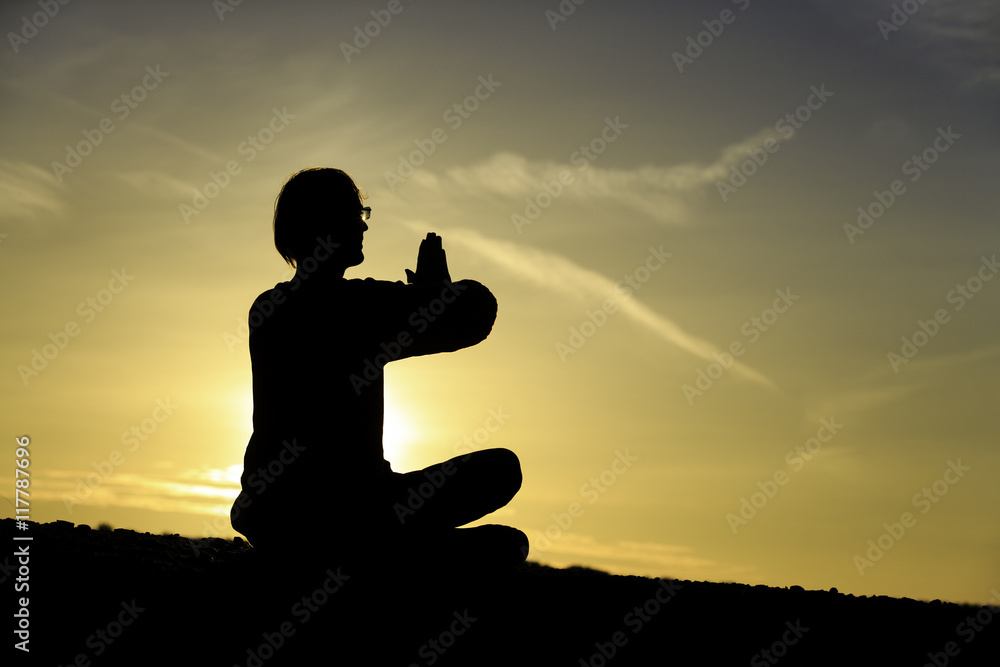 man doing yoga at sunset sky