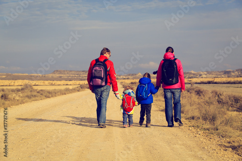 family with two kids walking on scenic road, tourism concept
