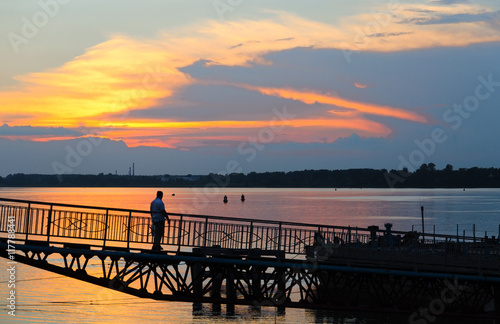 Man on river quay at sunset, Rybinsk, Russia