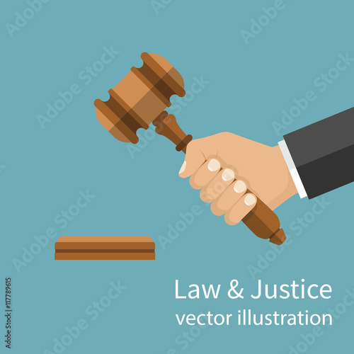 Hand holding judges gavel.