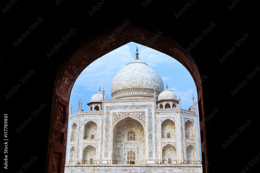 The Taj Mahal seen through a black archway.