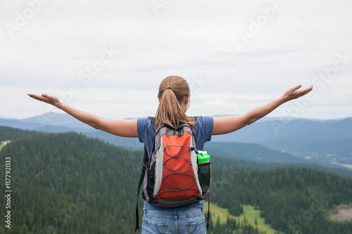 Young woman backpacker at mountain top. Happy and cheering concept