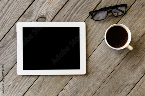 White tablet with blank screen on wooden table © kucherav