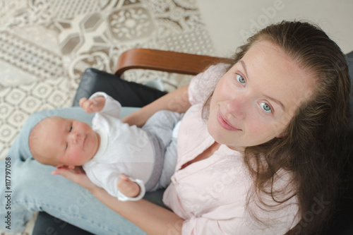 Young mother newborn her lap armchair top view